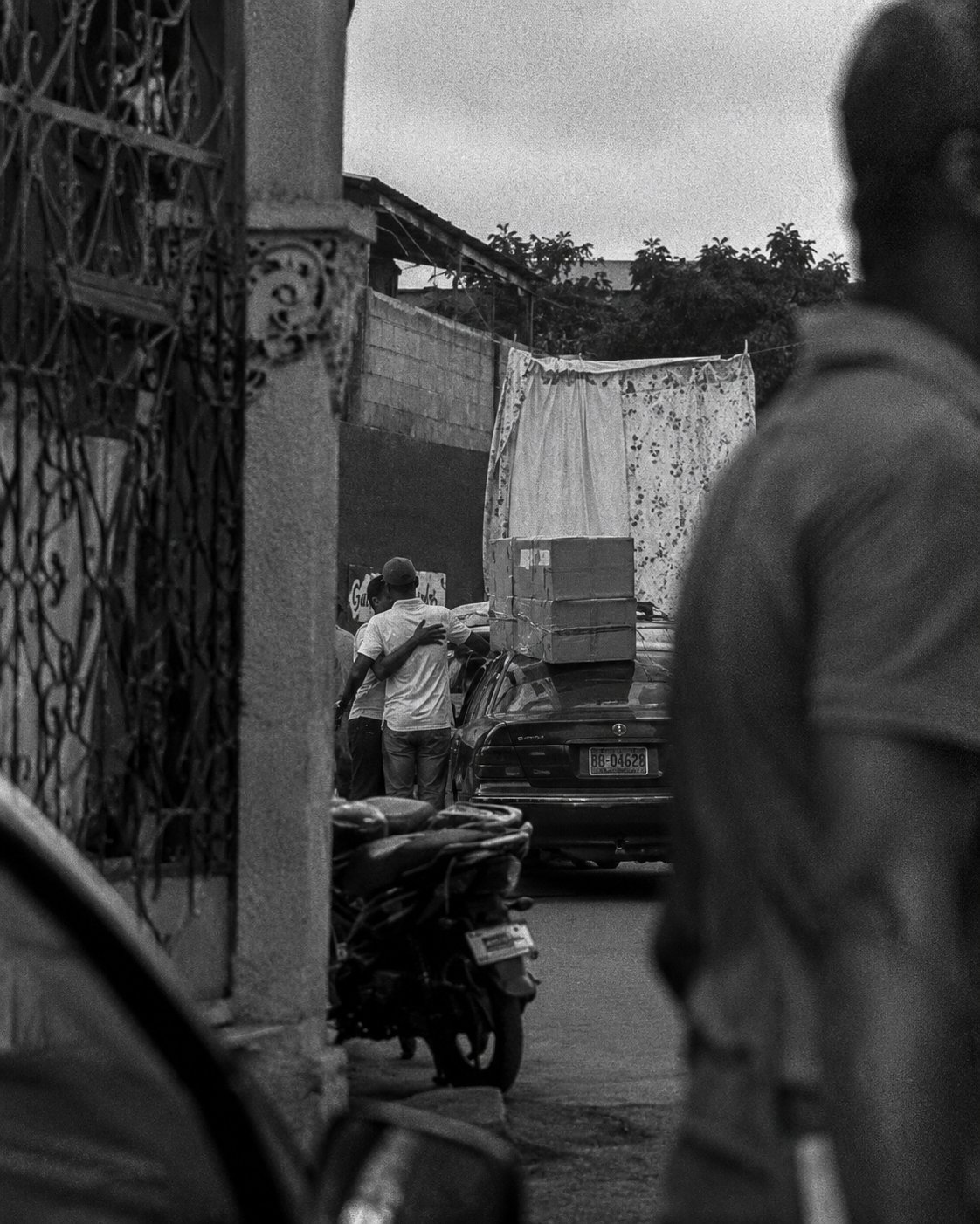 Black and white street scene with a moped and truck
