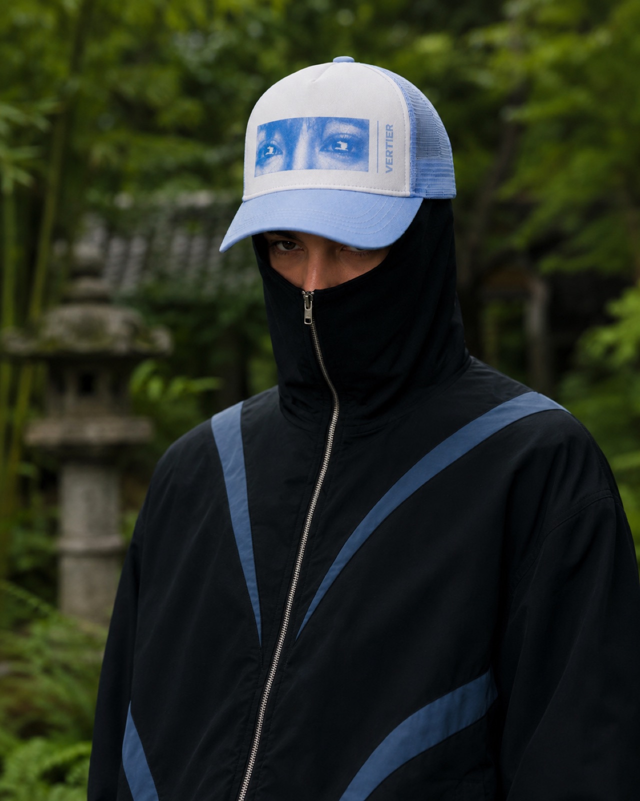 Front of the black palm track jacket in the garden
